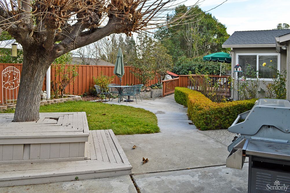 A cozy backyard with a patio, outdoor seating, and a well-maintained garden path.