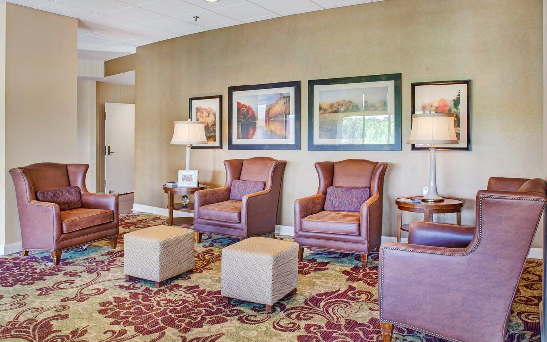 A cozy lobby seating area with armchairs and artwork on the walls.