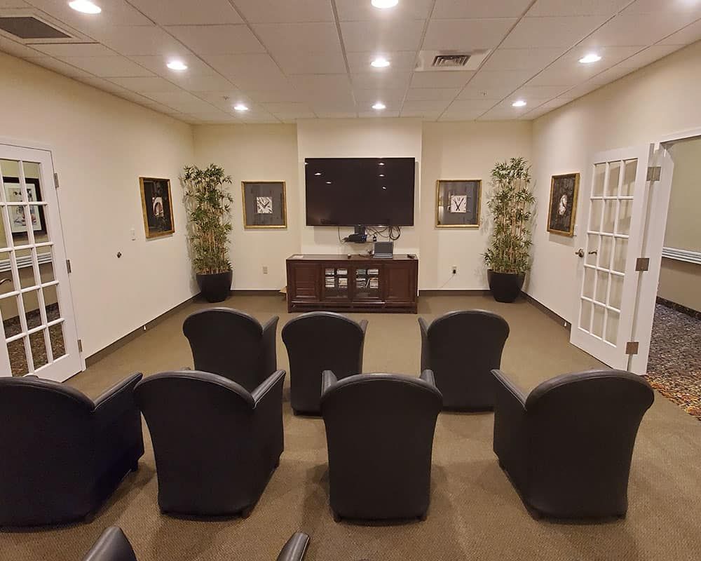 A small conference room with multiple chairs facing a television.