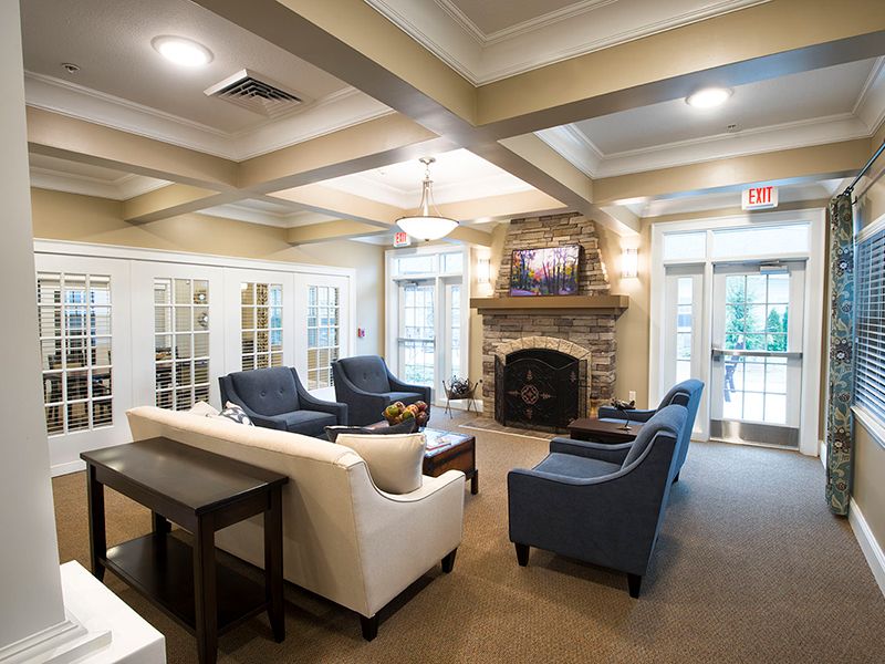 A cozy living room featuring comfortable seating and a stone fireplace.