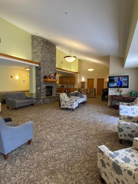 A spacious and comfortable lobby area with seating, a fireplace, and a television.
