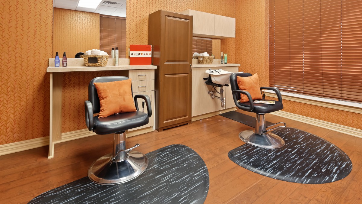 Modern hair salon with stylish barber chairs and mirrors.