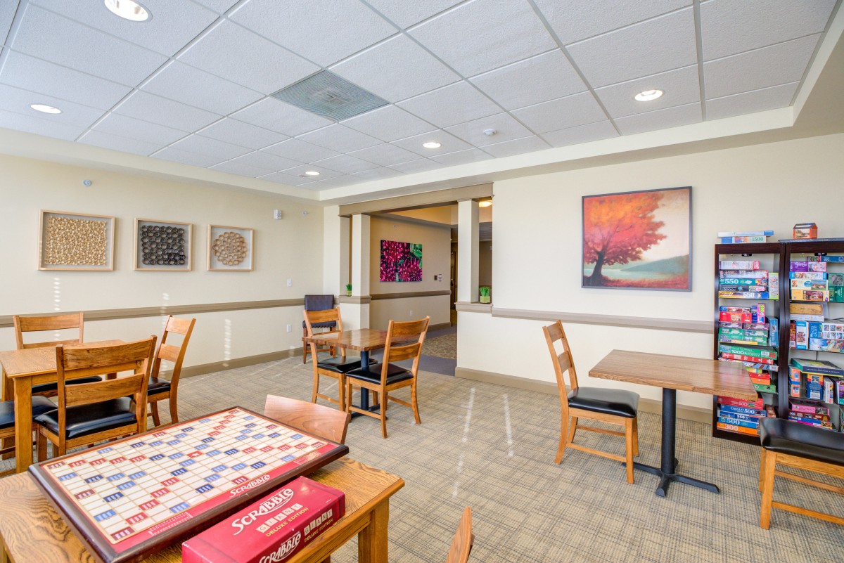 A spacious dining area featuring tables, chairs, and colorful artwork on the walls.