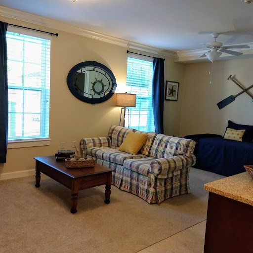 A cozy living room featuring a plaid sofa, wooden coffee table, and tasteful decor.