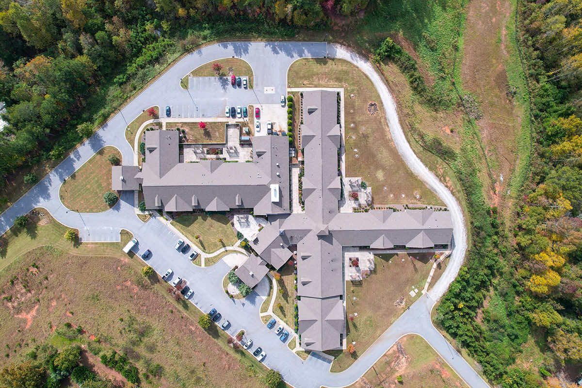 Aerial view of a building complex surrounded by roads and greenery.