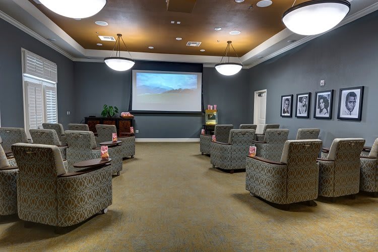 An empty theater room with comfortable seating and a large projector screen.