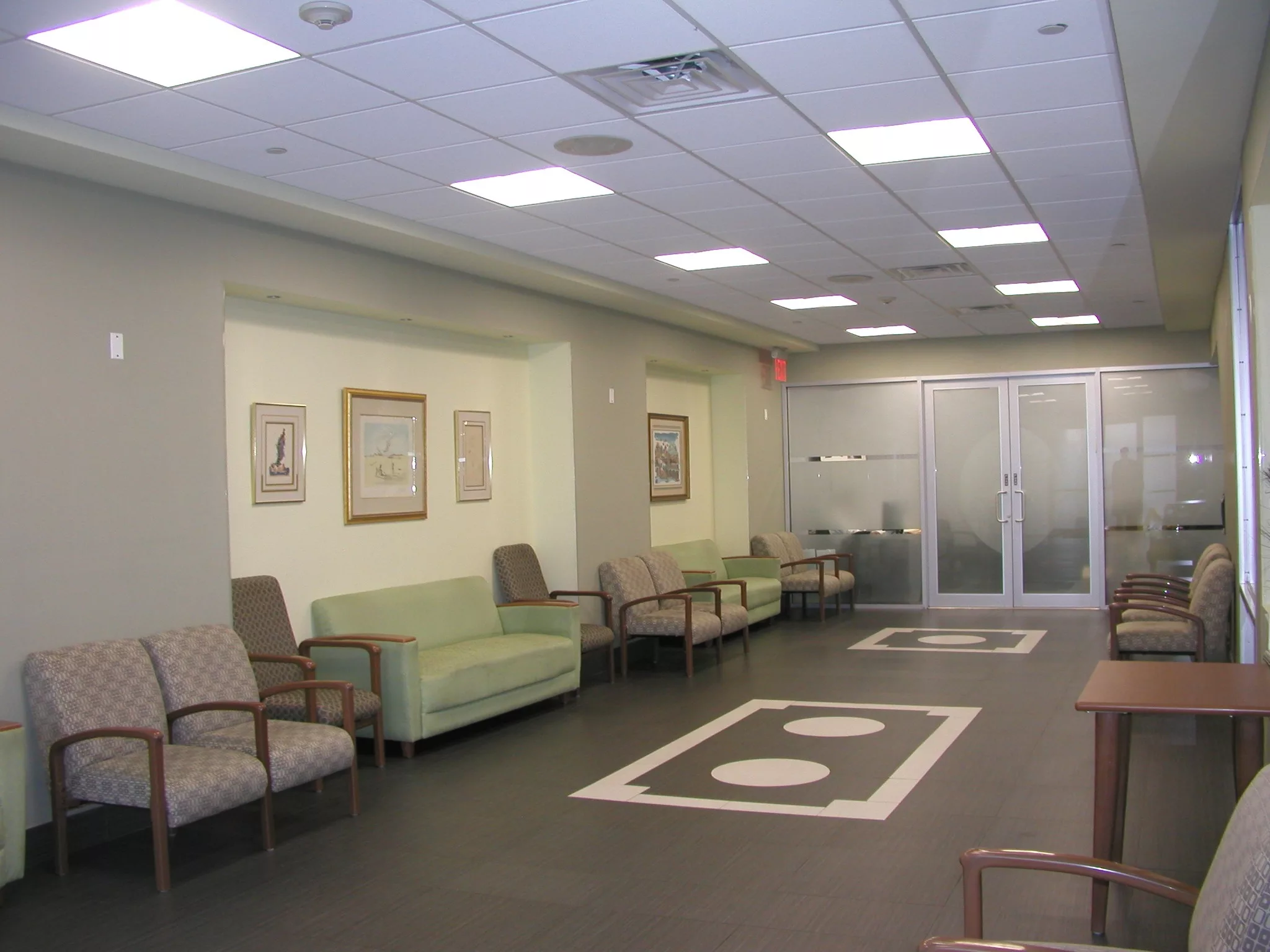 An empty waiting room with seating arrangements and modern lighting.