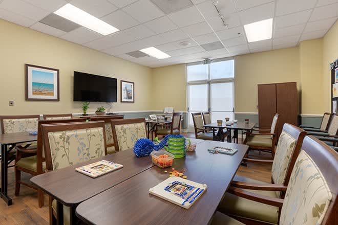 A well-lit meeting room with a large table, chairs, and a television.