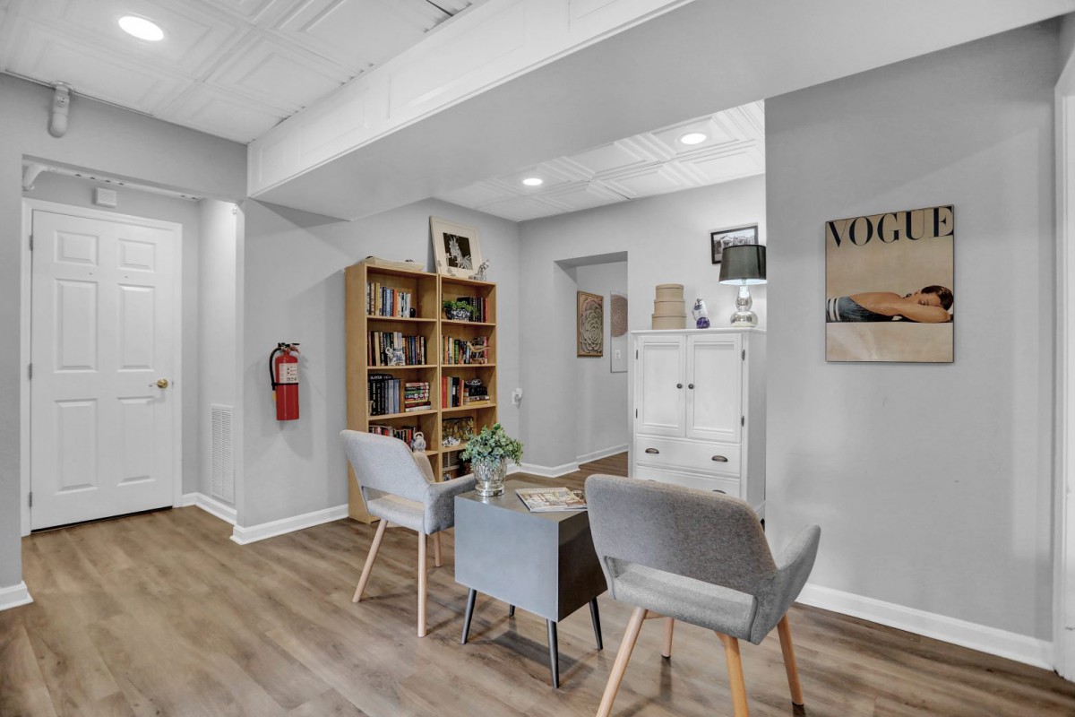 A modern waiting room with comfortable seating and a bookshelf filled with magazines.