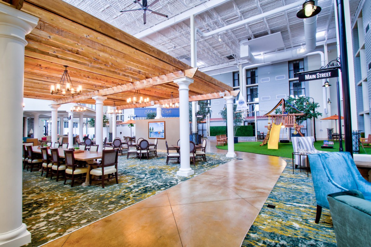 An indoor recreational space with seating, a pergola, and a children's play area.