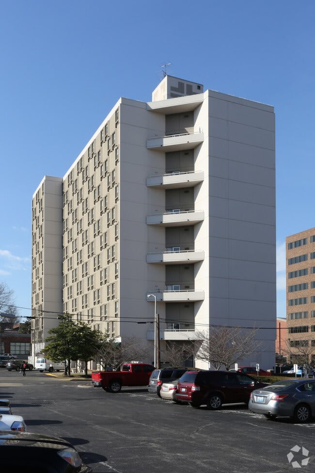A high-rise apartment building in an urban setting on a clear day.