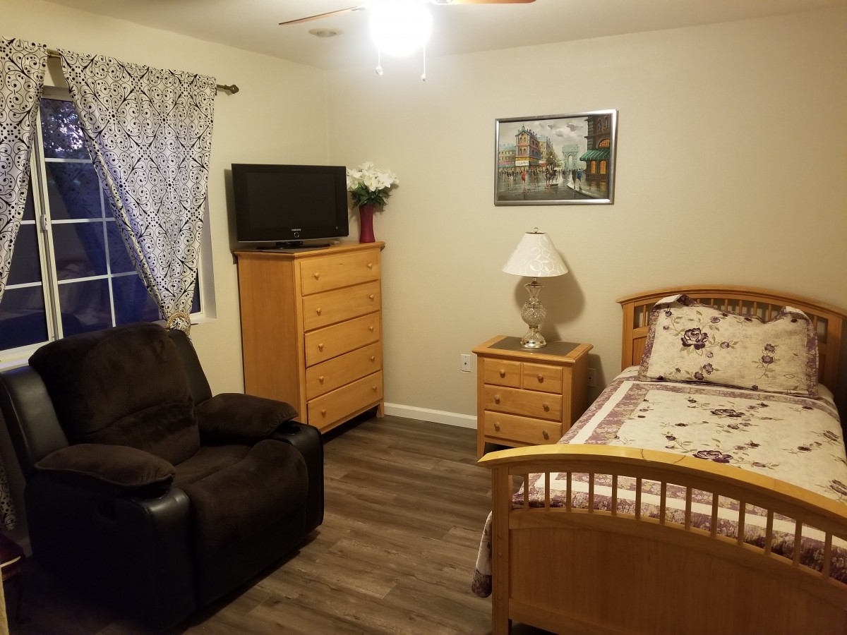 Cozy bedroom with wooden furniture and a TV.