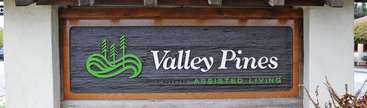 A wooden business sign for Valley Park Senior Assisted Living.
