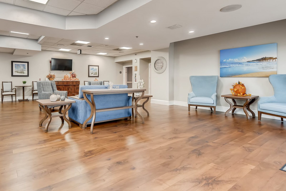 A modern and spacious living room with comfortable seating and a hardwood floor.