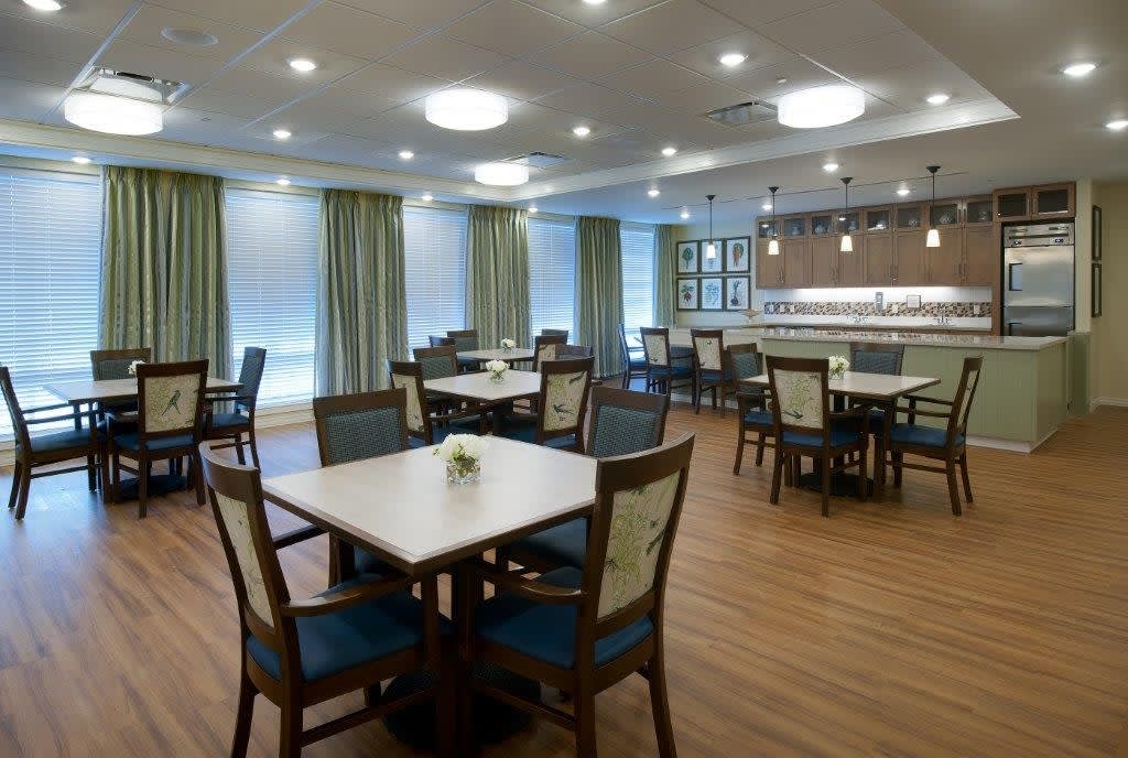 An elegant dining area with neatly arranged tables and chairs, complemented by soft lighting.