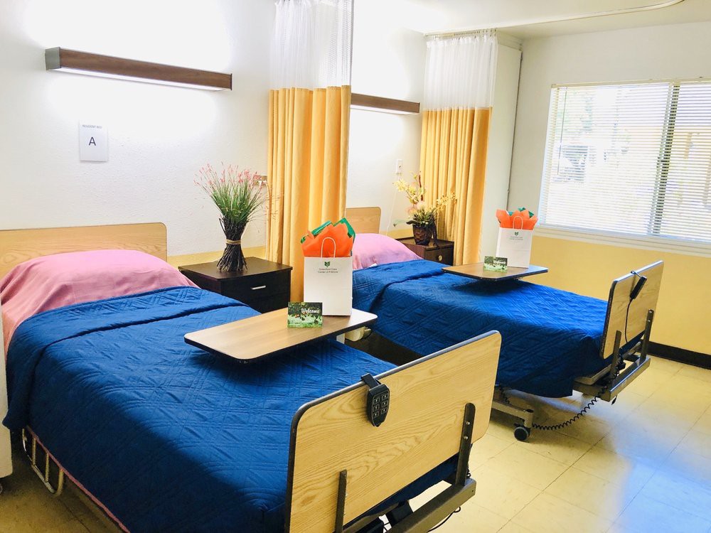 A clean and organized hospital room with two beds, each adorned with colorful sheets and decorative flowers.