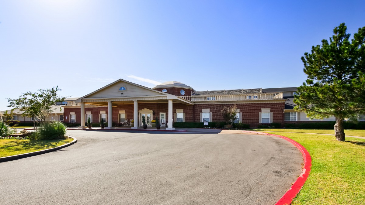 An exterior view of a building with a grand entrance and clear blue skies.