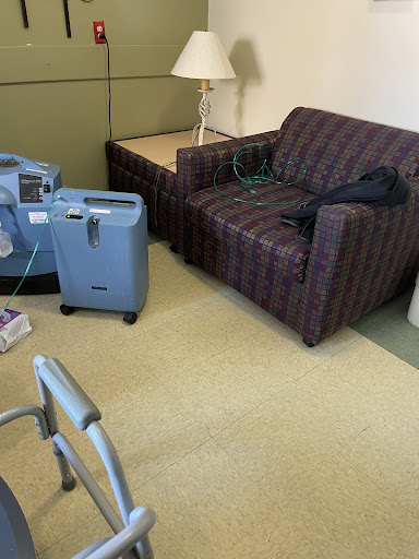 A view of a hospital room featuring a couch, medical equipment, and ambient lighting.