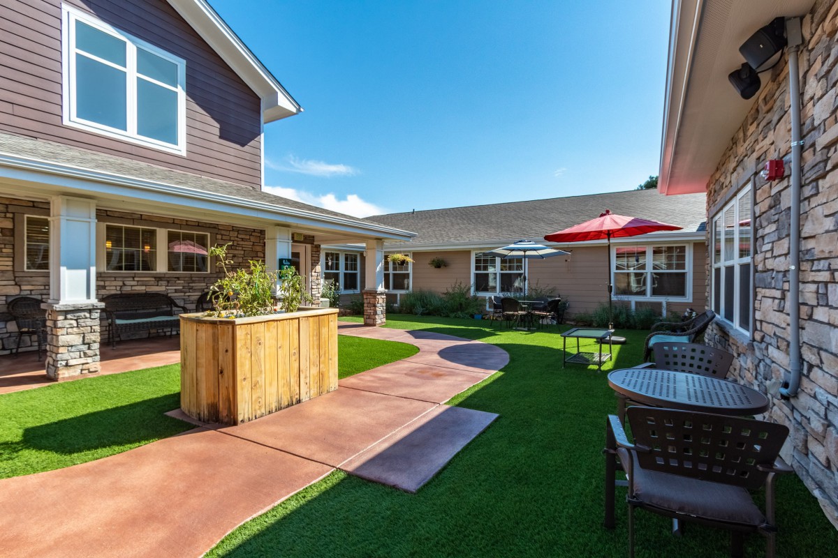 A sunny courtyard with outdoor seating and landscaped pathways.