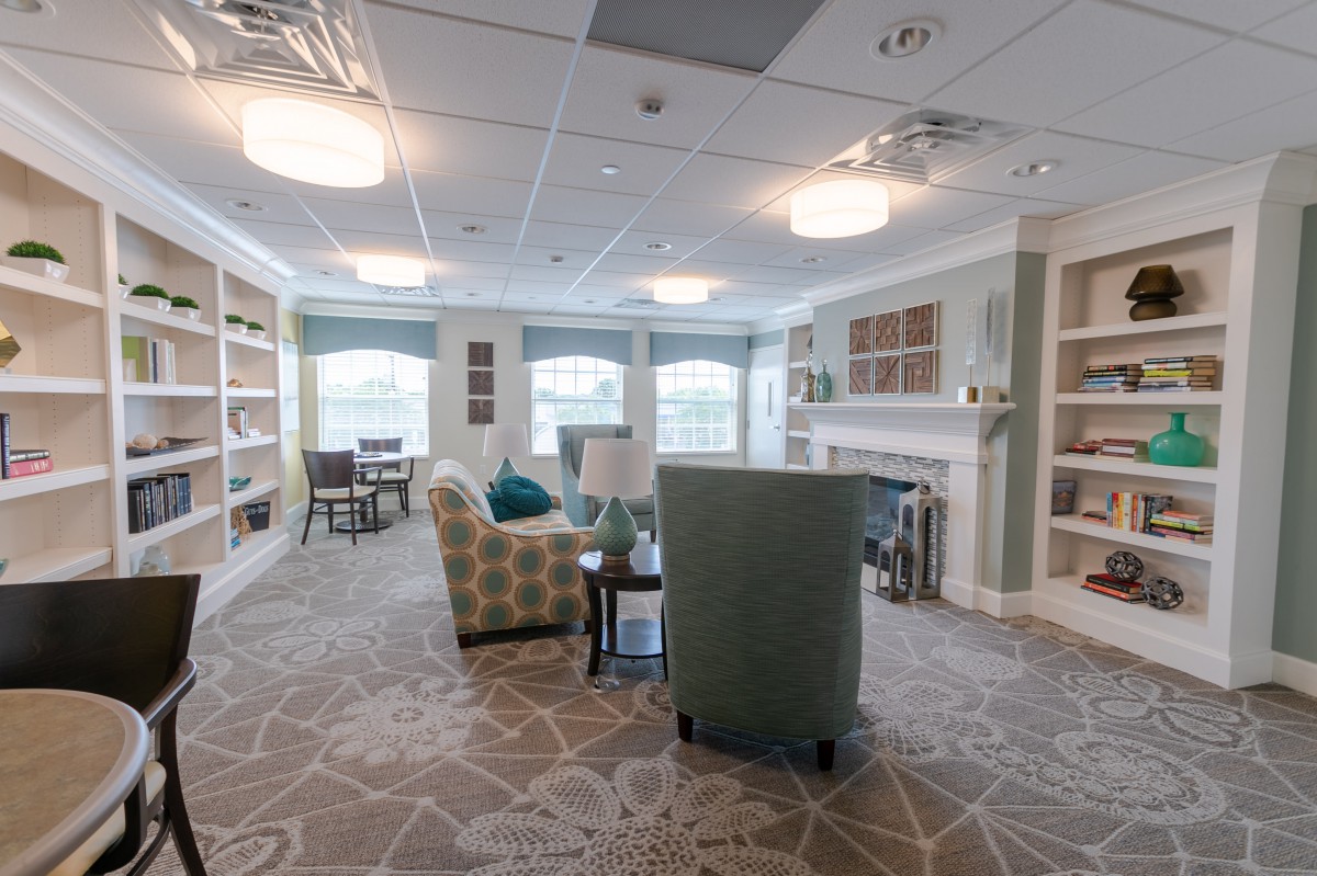 A cozy living room with comfortable seating, bookshelves, and soft lighting.