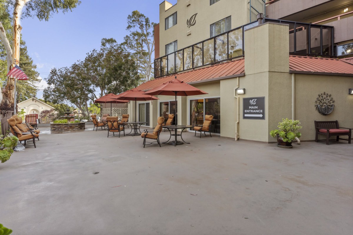 Outdoor seating area with umbrellas at a hotel patio.