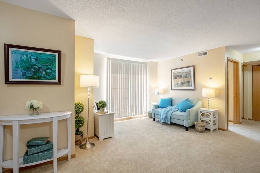 A cozy living room featuring blue-accented furniture and soft lighting.