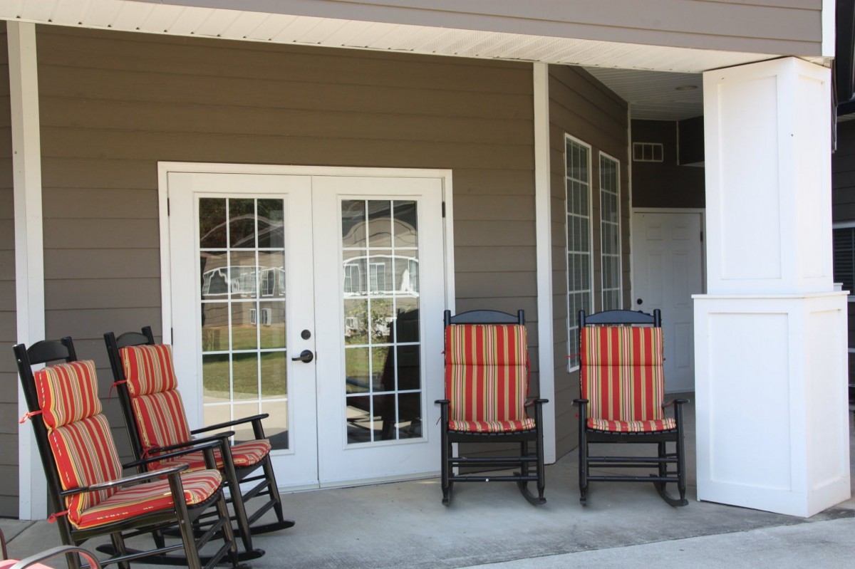 A cozy porch with striped rocking chairs and French doors leading outside.