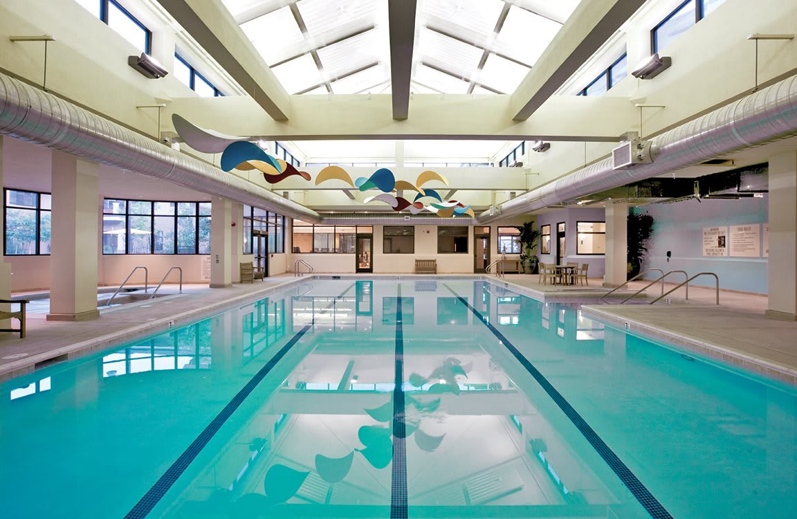 A spacious indoor swimming pool with a skylight roof, perfect for leisure and exercise.