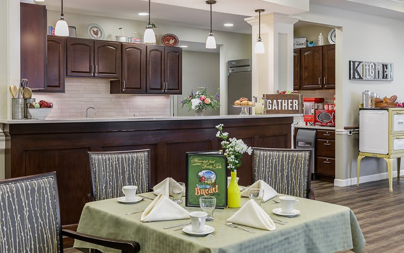A cozy dining area with a neatly set table and an open view of the kitchen.