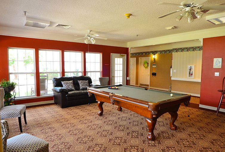 A cozy game room with a pool table and comfortable seating.