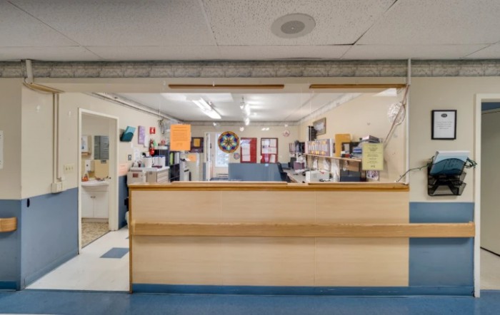 A reception area with a wooden counter and office supplies.
