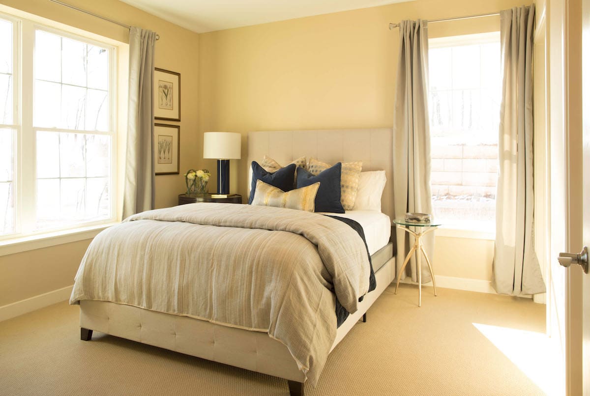 A cozy, modern bedroom with neutral tones and elegant decor.