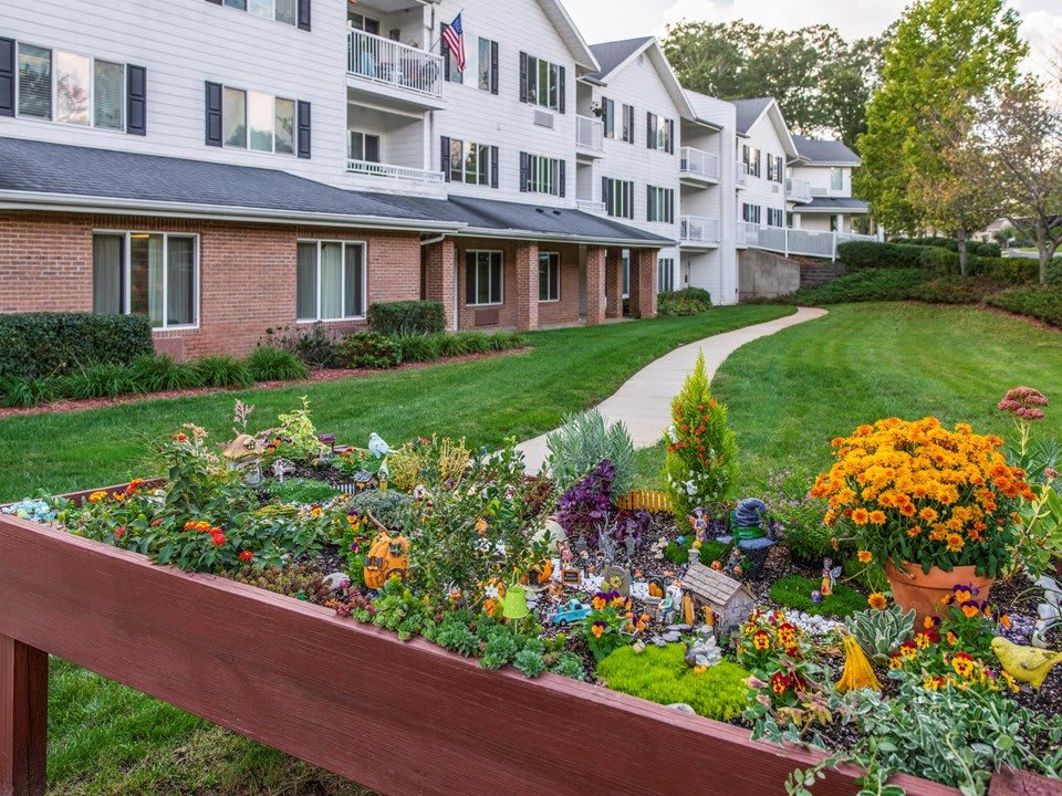 A well-maintained apartment complex with a vibrant garden and pathway.