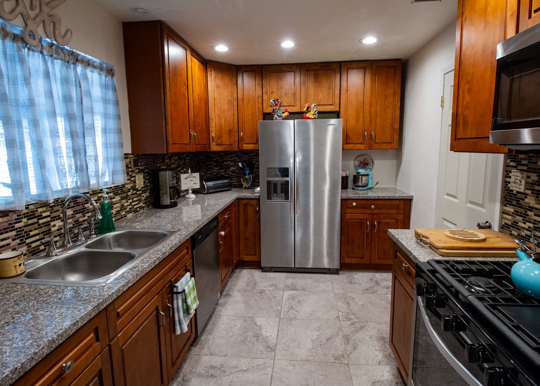 A modern kitchen with wooden cabinets and stainless steel appliances.