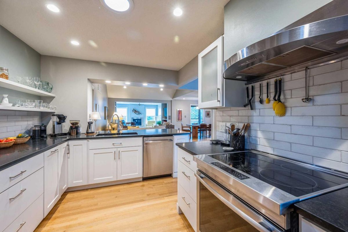 A modern kitchen with white cabinets and stainless steel appliances.