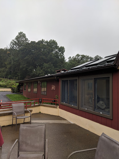 A rainy day view of a red building showcasing large windows and a terrace area.