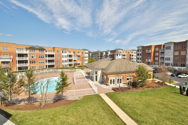 A modern suburban apartment complex with a swimming pool and landscaped grounds.