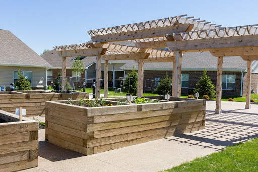 A beautifully designed outdoor garden area featuring wooden planters and a pergola, perfect for planting and relaxation.