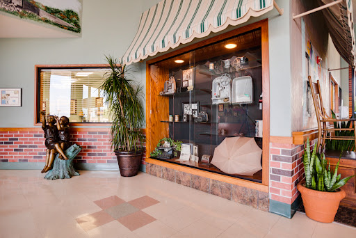 A cozy lobby featuring a display case showcasing various items, complemented by indoor plants.
