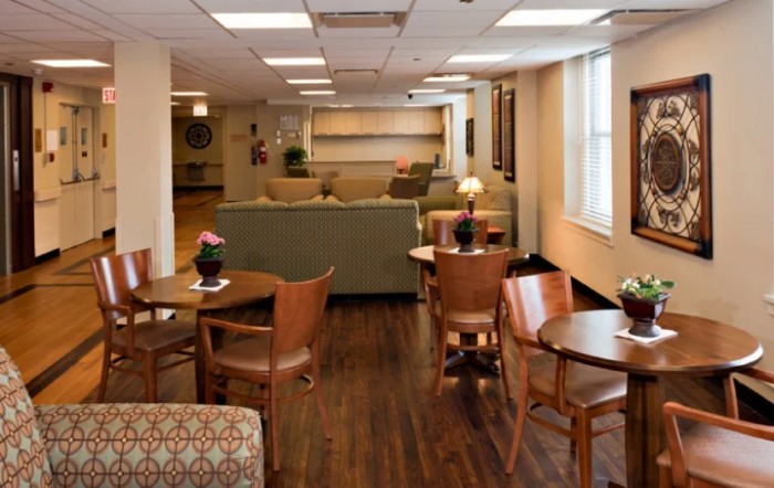 A cozy lounge area with tables and chairs, featuring comfortable seating and warm lighting.