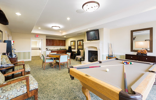 A cozy recreation room featuring a pool table, comfortable seating, and a dining area.