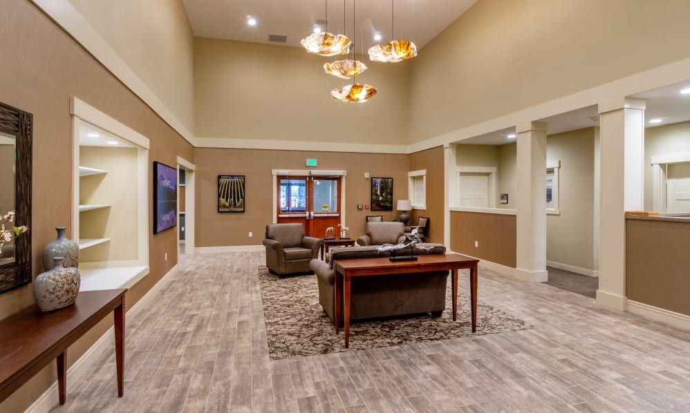 A spacious and modern living room featuring comfortable seating, elegant chandeliers, and tasteful decor.