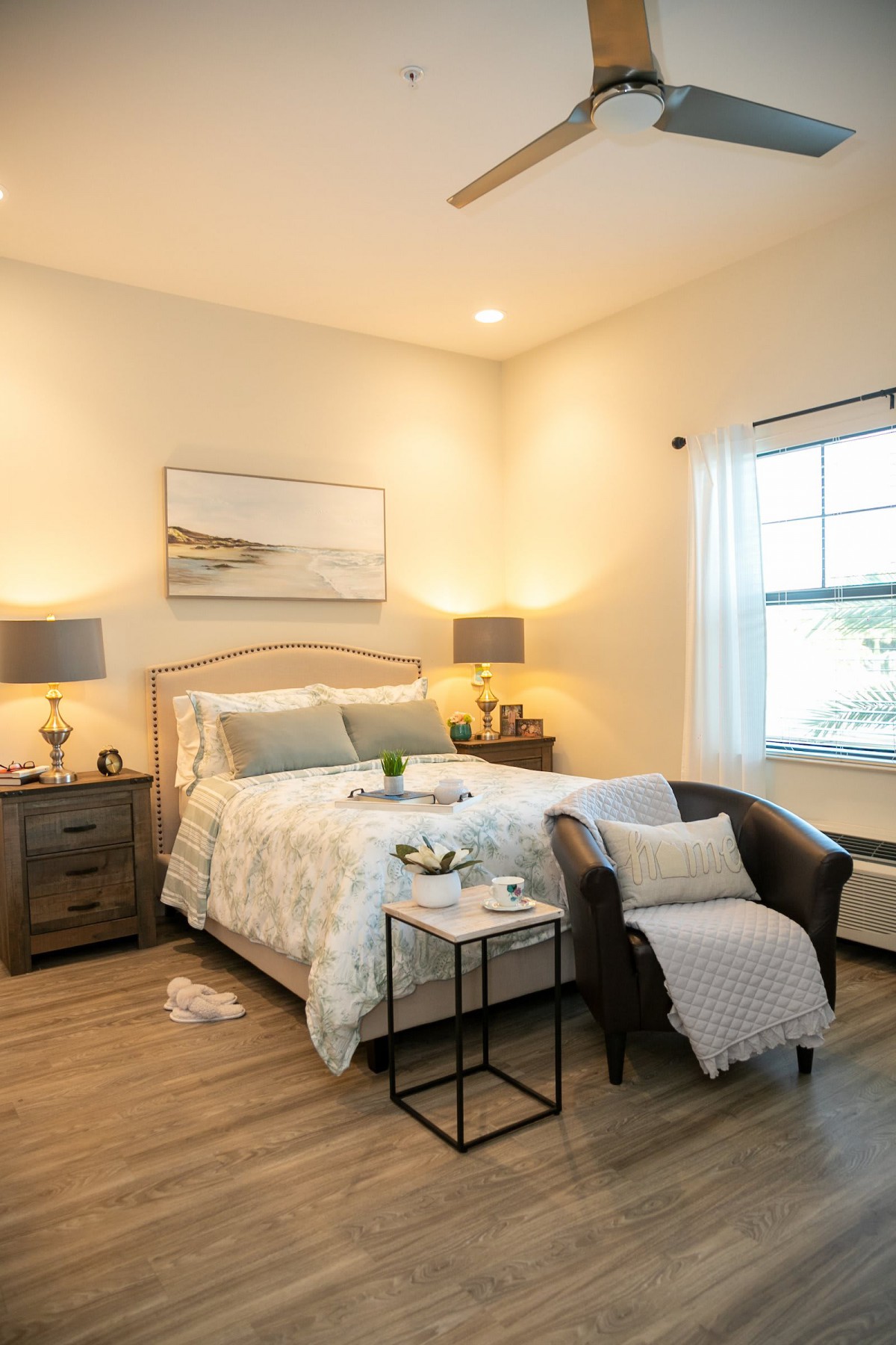 A cozy and stylishly decorated bedroom with a comfortable bed, bedside tables with lamps, and a window letting in natural light.