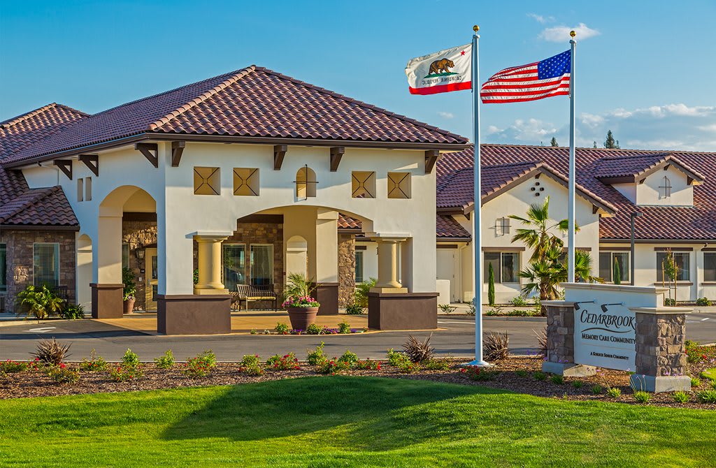 A residential building with the California and American flags displayed prominently in the front.