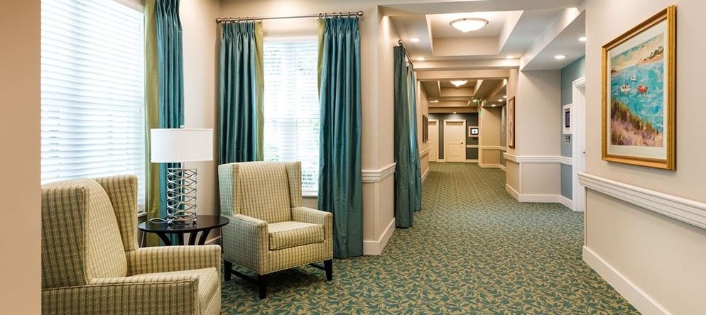 A well-lit hallway with comfortable seating and elegant curtains.