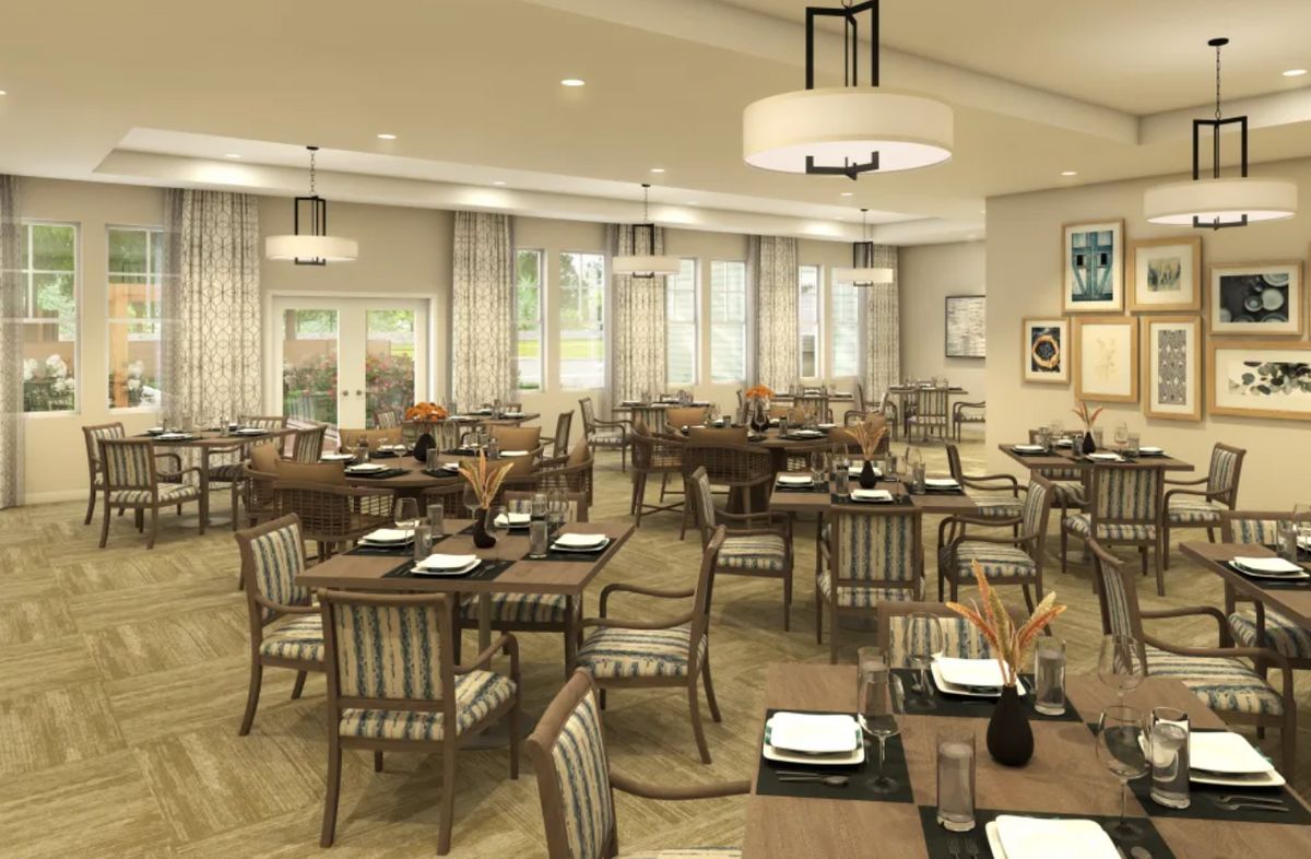 A spacious and elegantly decorated restaurant interior featuring neatly arranged tables and chairs.
