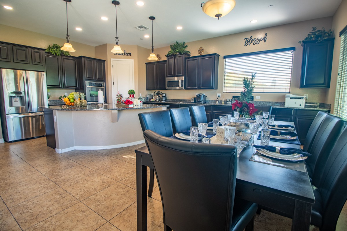 A modern dining area with a beautifully set table, adjacent to an open kitchen.