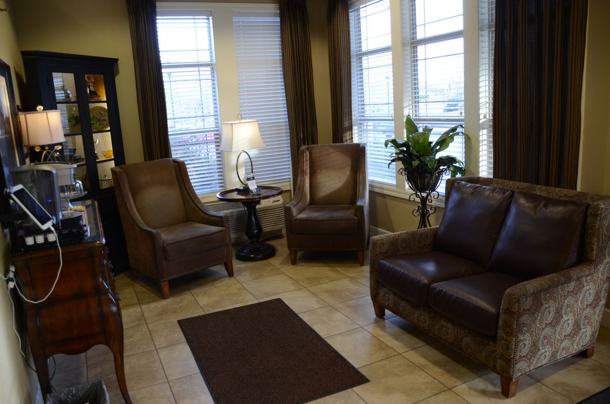 A cozy living room with leather chairs and warm lighting.