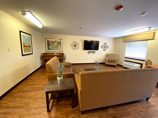 A cozy and inviting living room space featuring comfortable seating, a television, and decorative artwork.