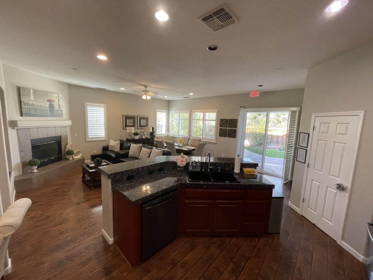 A modern open-plan living room and kitchen area with hardwood floors and contemporary furniture.